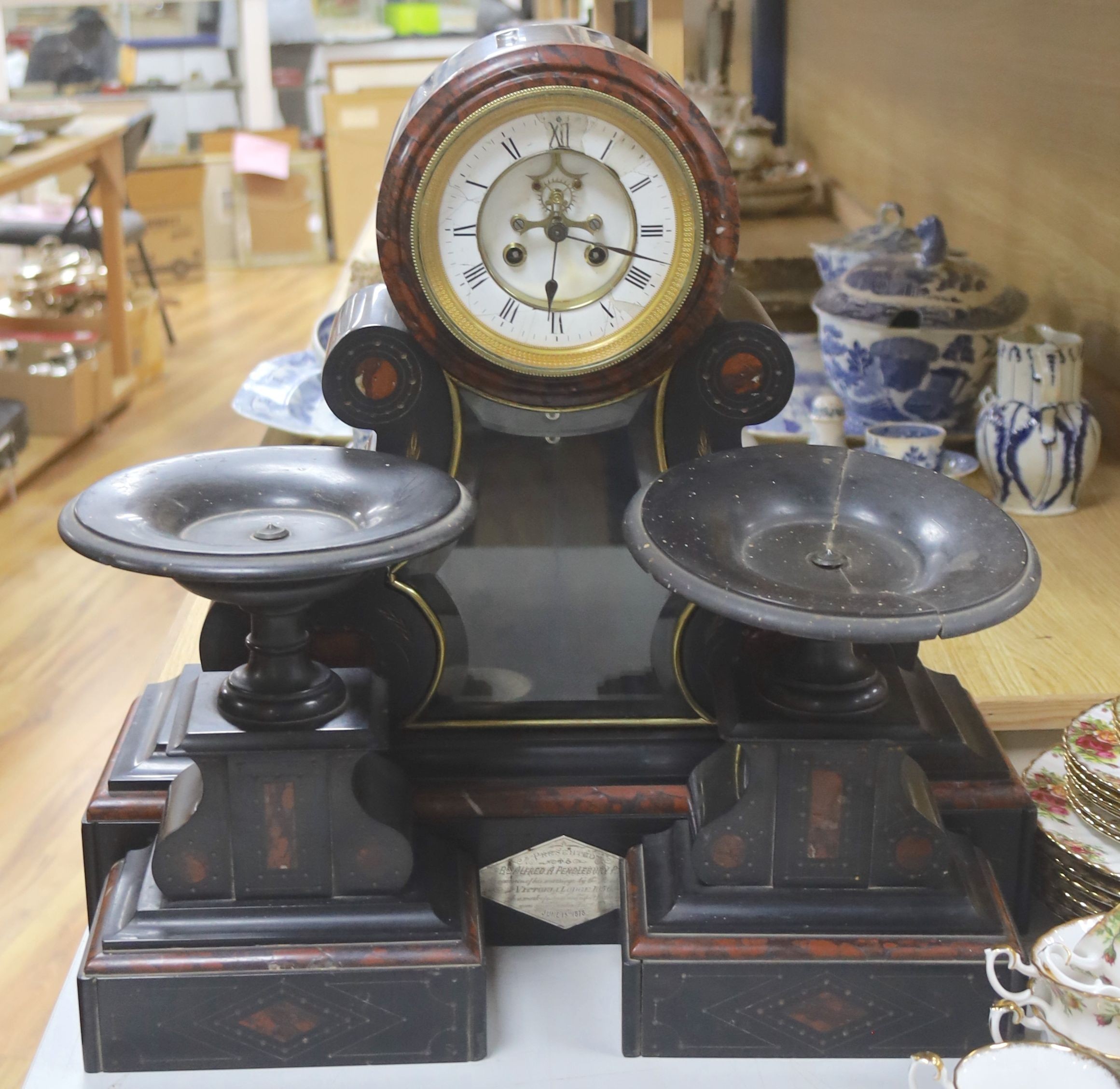 A 19th century Victorian slate clock garniture, the movement with visible Brocot escapement with key and pendulum (af), clock 49cm high